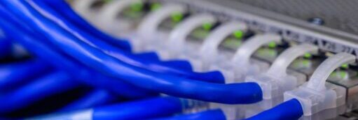 Detailed view of blue ethernet cables connected to a network switch in a data center.